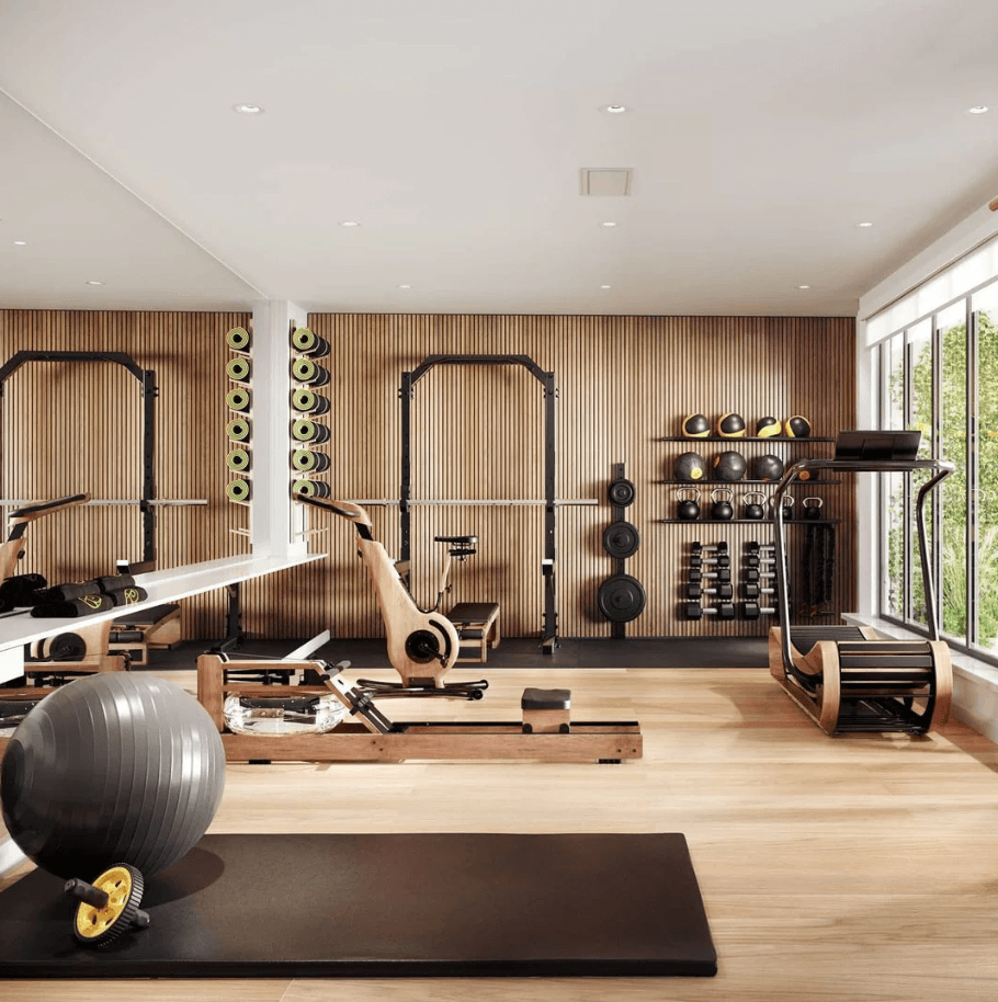 A modern home gym with wooden walls, featuring various exercise equipment including weight racks, exercise balls, and fitness machines.